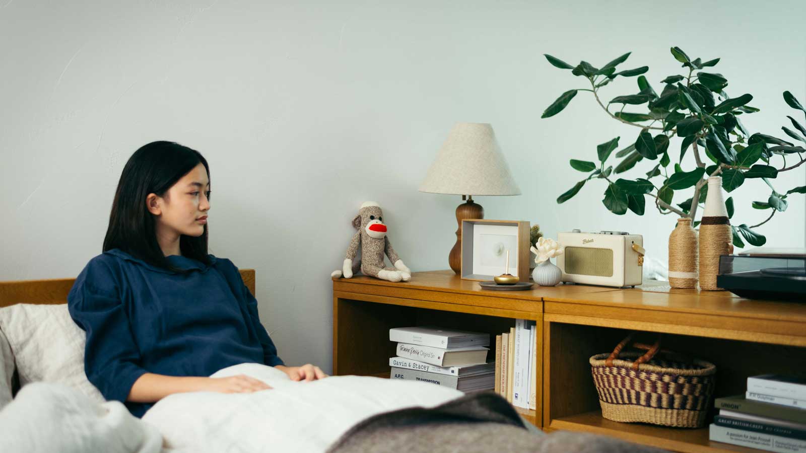 棚に飾った写真立てを見つめる女性