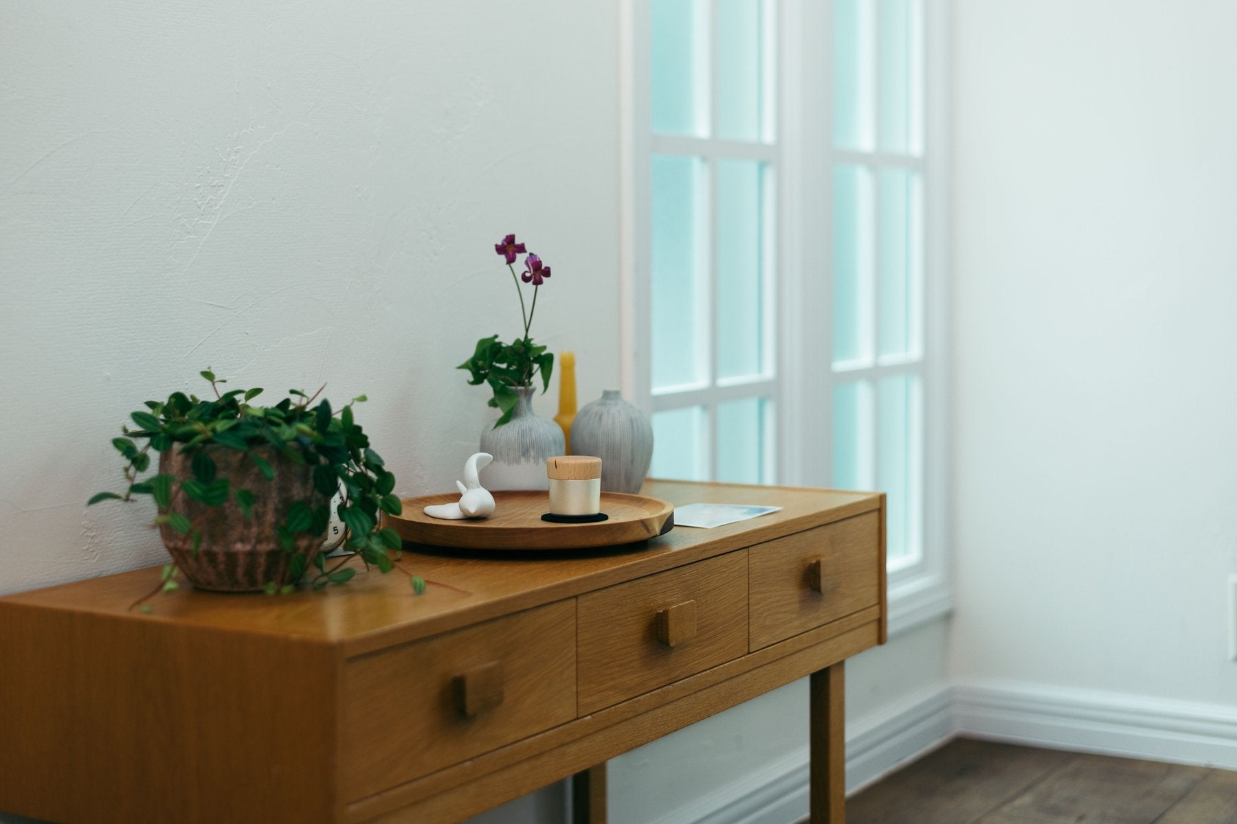 木製サイドボードの上に、観葉植物や花瓶、写真立てとともにPictuary Cylinderを置いた生活シーン