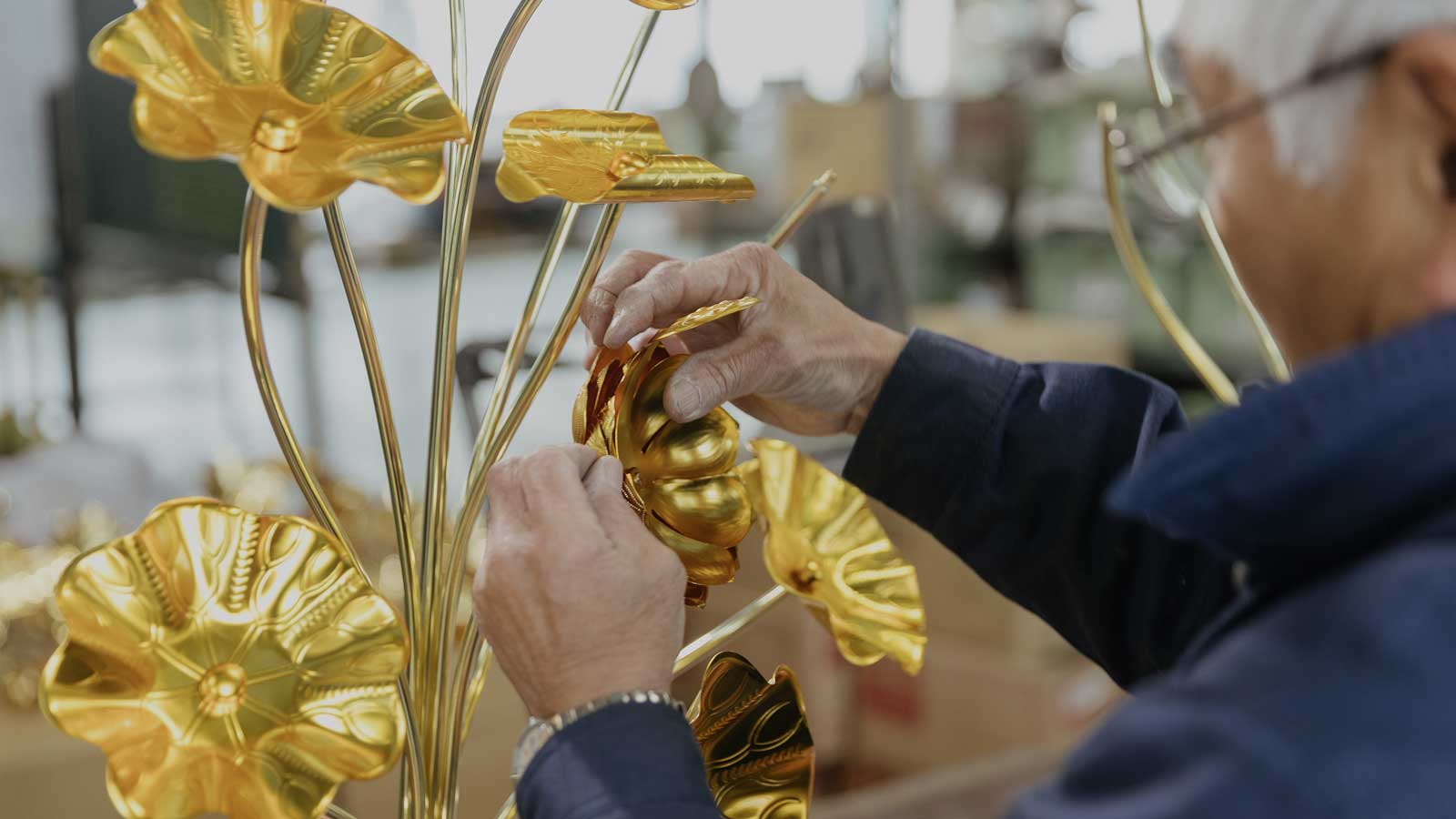 金色の常花を組み立てる職人の手元